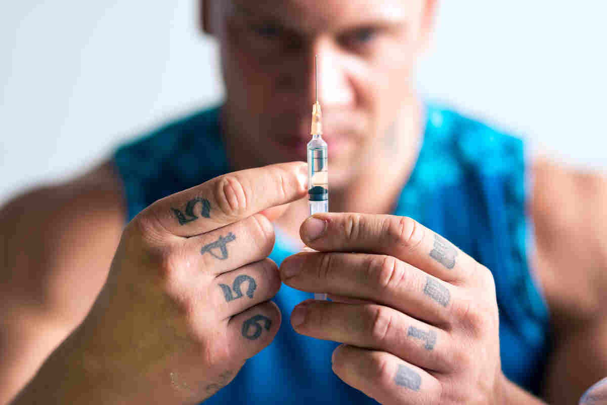 body builder holding syringe